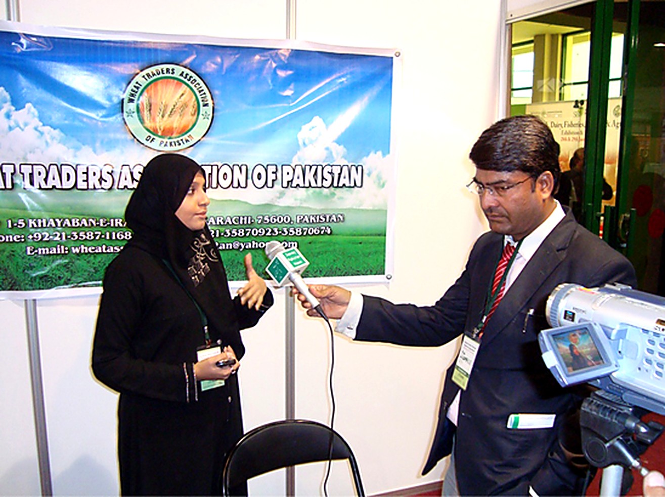 Television reporter interviewing a WTAP delegate in front of the association banner