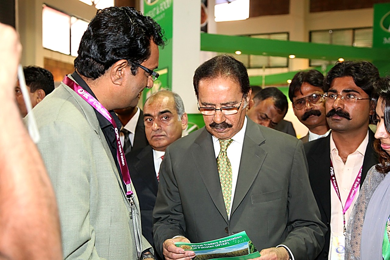 Government dignitary reading a Wheat Traders Association of Pakistan brochure at the association stand